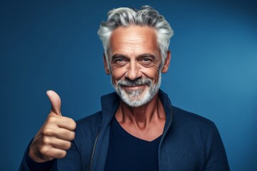 Close-up portrait photography of a glad mature man showing a thumb up against a sapphire blue background. With generative AI technology