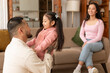 © Prostock-studio - Japanese Woman Looking At Husband Hugging Their Little Daughter Indoor