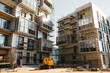 © AvokadoStudio - Development of modern residential building with lifting crane. Glass surface with sunlight