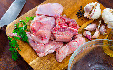 Canvas Print - Delicious cutting rabbit meat with spices, knife and herbs on kitchen board