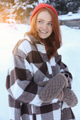 Wall Mural - Portrait of beautiful young woman on snowy day outdoors. Winter vacation