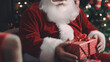 © wetzkaz - Santa Claus gives or wraps Christmas gifts, close-up hands, red Santa Claus costume, sits on a chair next to the decorated Christmas tree