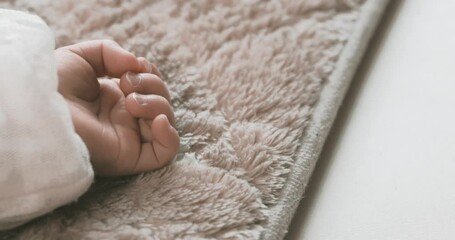 Sticker - A 2x slow motion of sleeping asian baby left hand on the carpet handheld