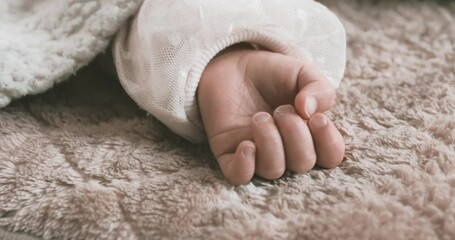 Wall Mural - A 2x slow motion of sleeping asian baby left hand on the carpet handheld