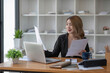© chartchai - Asian businesswoman working in the office with working documents.