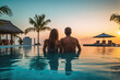 © radekcho - Young couple traveler relaxing and enjoying the sunset by a tropical resort pool while traveling for summer vacation