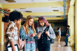 © Drazen - Group of high school students using cell phone in hallway.
