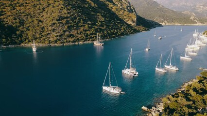 Wall Mural - Beautiful aerial view of yachts and boats anchoring in a bay in Aegean sea with clear turquoise water