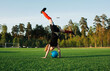 © Cavan Images - girl doing a handstand over a football in a football pitch
