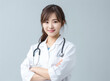 © Surachetsh - Confident Japanese young doctor woman in a medical uniform stands before a white background, illuminated by studio lights. generative AI.