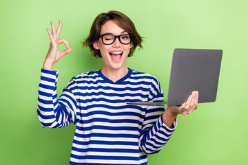 photo of young smart woman business specialist manager show okey sign deal hold netbook blink eye hi