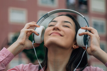 Wall Mural - smiling relaxed woman in the street with headphones