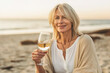 © Kalim - Illustration of mature senior woman with wine on the beach
