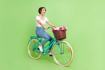 Poster - Full length photo of excited funky lady wear white top riding fast bicycle isolated green color background