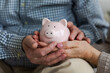 Saving money investment for future. Senior adult mature couple hands holding piggy bank with money coin. Old man woman counting saving money planning retirement budget. Investment banking concept