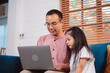 © Kiattisak - Cute little asian daughter with father working on laptop at home. single loving dad man shopping insurance to daughter by online technology.