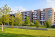 © alpegor - New apartment buildings along a public park warmly lit by a setting sun in spring