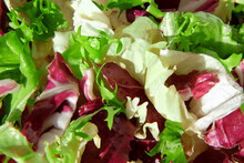Fresh Mixed Salad Field Greens Piled Closeup Top View. Various Vegetable Leaves Wallpaper. Healthy Juicy Salad Mix With Frisee, Radicchio, Chard Leaf And Lettuce Is Spinning, Rotation. Mixed Greens