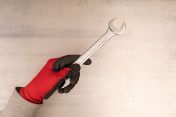 Canvas Print -  Closeup mans hand holds a wrench isolated on white