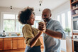 © InputUX - Authentic moment of an African American retired couple sharing a dance in the kitchen, an embodiment of enduring love and romance, generative ai