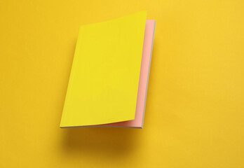 Poster - Notepad with a yellow cover floating on a yellow background