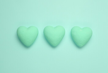 Wall Mural - Three blue hearts on a blue background. Minimal love still life