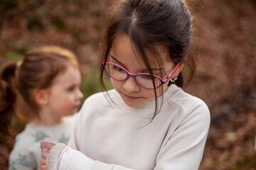 Wall Mural - Portrait of two little girls with broken arm in the park.