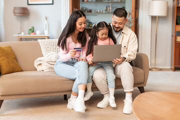 Wall Mural - Korean Family With Child Using Laptop For Online Fun Indoors