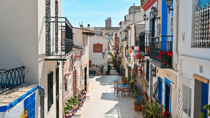 Naklejka na meble A street with potted flowers and colorful houses in Alicante