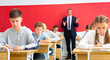 © JackF - Group of focused teenage students sitting at classroom working at class