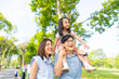 © CandyRetriever  - Happy Asian family spending time together travel on summer holiday vacation. Parent and little child enjoy and fun outdoor activity lifestyle walking and playing together at public park in the city.