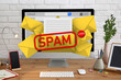 Spam warning message in email software. Envelope illustrations popping out of computer display on office desk