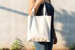 a young girl  wearing black holding blank white tote bag in a sunny day, mockup design, Generative AI