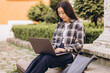 © anatoliycherkas - Freelance young adult asian woman using laptop computer for work. Sitting at outdoor on day. Urban people lifestyle with modern technology.
