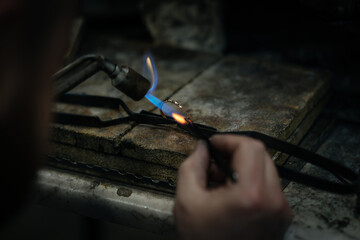 Craftsman is working by using a Gas spraying tool to make a ring