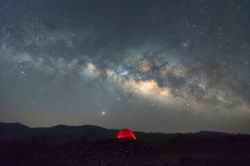 Wall Mural - Red tent in reservoir under Milky way galaxy with stars and space dust in the universe, long speed exposure with noise. Baan Sop pat, Mae Moh Lampang Thailand.