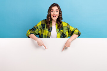 Canvas Print - Photo of sweet excited woman dressed plaid shirt pointing two fingers poster empty space isolated blue color background