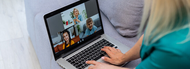 Wall Mural - Cropped image of young woman using laptop for video conference at home