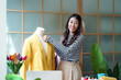 © freebird7977 - Young women fashion designer using laptop working and design tailor and cloth in the showroom,  Lifestyle Stylish tailor taking measurements on mannequin for cutting cloths in studio
