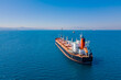 Bulk vessel for dry cargo in anchorage in sea waiting loading in industrial port, aerial shot