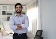 © Nassorn - Portrait of indian businessman happy standing arms crossed in modern office. Confident young smart bearded man entrepreneur looking at camera smiling. Friendly india ethnic manager work in workplace.
