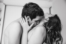 Young Passionate Couple (two Lovers) Kissing On The Neck For Intense Sex In The Bedroom, Young Tender Lover Touching The Skin Of A Sexy Sensual Lady Moaning And Making Love. Foreplay Concept.