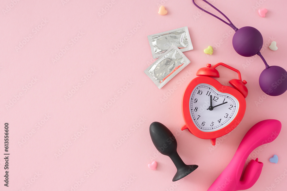 Photo Stock Exploring pleasure with sex toys. Top view flat lay of  vibrator, anal plug, vaginal balls, condoms, hearts and shaped heart alarm  clock on pastel pink background with empty space for