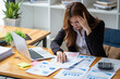 © Wuttichaik - Tired exhausted  fatigue angry business woman manager bookkeeping law firm accounting bored sleepy sitting at desk, business woman stressed about meeting online project document on laptop computer