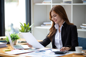 successful happy smiling businesswoman saleswoman working on laptop computer, young female making on