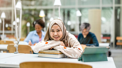 Wall Mural - Multiethnic group of students sitting in a library and studying together
