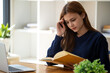 © Wuttichaik - Stress, student with laptop at home frustrated agry unhappy young woman looking at laptop screen book, Exhausted female student studying online with computer