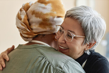 Closeup of two senior women embracing cheerfully and supporting each other