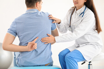 Poster - Female doctor checking posture of young man in clinic