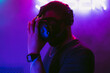 © callisto - Man in a virtual reality helmet. Neon room with VR games.